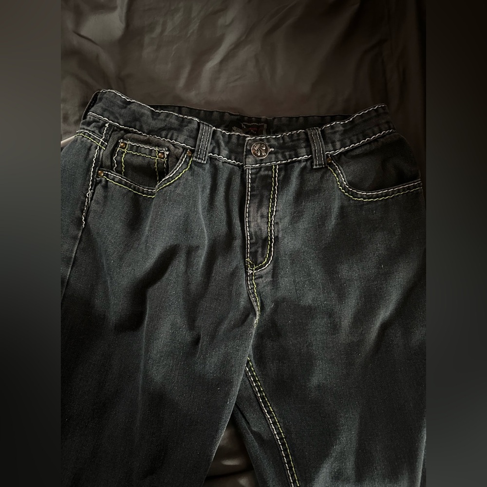 washed black Patroncito jeans with green and white stitching, designs on back